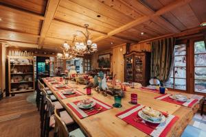 a dining room with a large wooden table with chairs at Megève Bois - Relais & Châteaux in Demi-Quartier