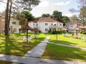 a walkway in front of a house with tables and chairs at Del Pinar Apart in Costa del Este