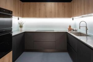 a kitchen with wooden cabinets and a sink at VILLA OXA 12&2, Emma Villas in Imola