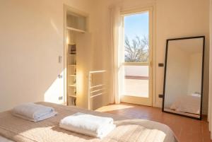 a bedroom with a bed and a mirror and a door at VILLA OXA 12&2, Emma Villas in Imola +30 photos