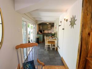 a small kitchen and dining room with a table at Woodman's Lodge in Moelfre +17 photos