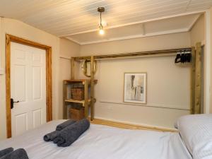 a bedroom with a white bed and a white ceiling at Woodman's Lodge in Moelfre