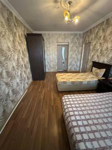 a bedroom with two beds and a wooden floor at Evv in Naxçıvan