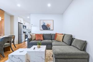 a living room with a couch and a table at Casa Hotels Gerrard Modern Downtown Suite in Toronto
