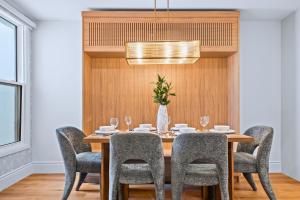 a dining room with a wooden table and chairs at Casa Hotels Gerrard Modern Downtown Suite in Toronto