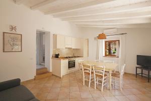 a kitchen and dining room with a table and chairs at Appartamento il Caracolo a Cala Francese in La Maddalena