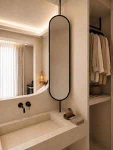 a bathroom with a large mirror and a sink at RHODEA Mar in Faliraki