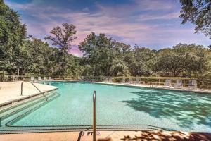 a large swimming pool with chairs and trees at Inlet Cove 94 in Kiawah Island