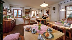 a dining room with tables and people in the background at Gästehaus Lechner in Bernau am Chiemsee