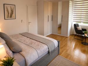 a bedroom with a bed and a chair in it at Villa Schönfeld in Schönfeld