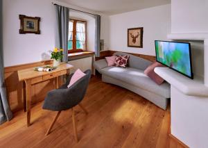a living room with a couch and a tv at Gästehaus Lechner in Bernau am Chiemsee