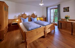 a bedroom with a large wooden bed with blue pillows at Gästehaus Lechner in Bernau am Chiemsee