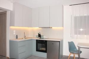 a kitchen with white cabinets and a sink at Thassos Studio Kai Lani in Potamiá +31 photos