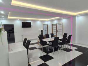 a dining room with a table and black chairs at Agroturystyka Gorajec Zagroble in Wólka Czarnystok
