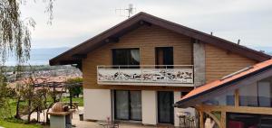 a house with a balcony on top of it at Le nid bucolique in Publier
