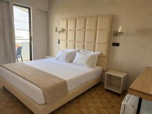 a bedroom with a large bed with a large headboard at RHODEA Mar in Faliraki