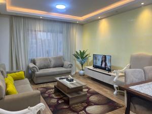 a living room with a couch and a tv at SUNSKY Apartment Hotel in New cairo