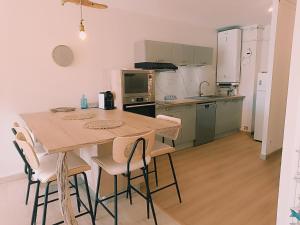 a kitchen with a table and chairs in a room at Les pieds dans l'eau in Mèze