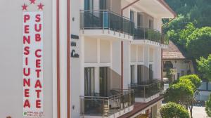 a building with a sign on the side of it at Sub Cetate in Râşnov