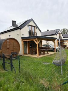 a house with a porch and a hammock in the yard at Zagroda ciszy in Lubiatowo