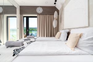 two large beds in a room with windows at Lake Chwil 5618 widok na zalew i góry in Sosnówka +65 photos