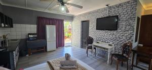 a living room with a tv on a brick wall at GerSan Oasis in Nigel