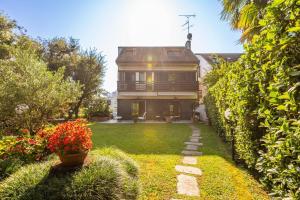 a large house with a yard with flowers at Villa San Siro Olympic Stadium in Milan