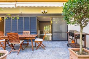 a patio with a wooden table and chairs at Villa San Siro Olympic Stadium in Milan