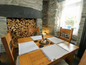 a wooden table with two chairs and a fireplace at Garreg Ddu in Blaenau-Ffestiniog