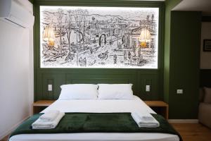 a bed in a room with a drawing on the wall at Tomas Inn in Pogradec