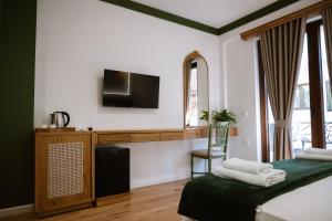 a bedroom with two beds and a television on a wall at Tomas Inn in Pogradec +50 photos