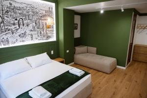 a green bedroom with a bed and a chair at Tomas Inn in Pogradec