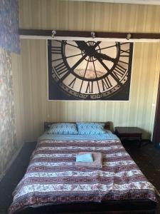 a bed with a large clock on the wall at AURa in Zhytomyr