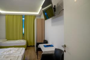 a room with two beds and a tv on the wall at Hotel - Restaurant Valley Rose in Vienna