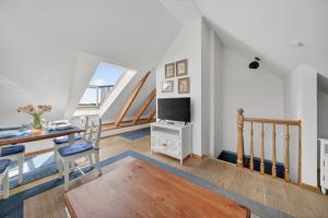 a living room with a dining table and a television at Liiger-Hoern-DG-Wohnung-4-Moewe in Tinnum