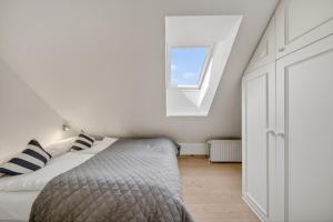 a bedroom with a bed and a window at Liiger-Hoern-DG-Wohnung-4-Moewe in Tinnum