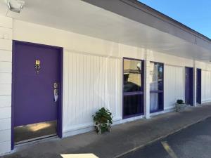 a purple door on the side of a building at Motel Masquerade in Marksville +13 photos