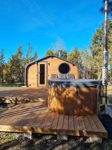 a tiny house with a hot tub on a deck at Kivipalu kämping in Allika