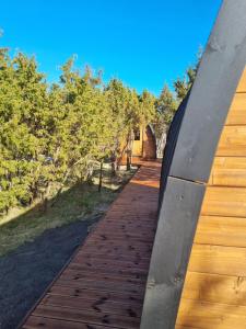 a wooden walkway with a bridge in the background at Kivipalu kämping in Allika