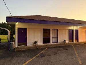a building with a parking lot at Motel Masquerade in Marksville