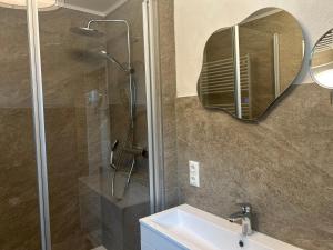 a bathroom with a shower and a sink and a mirror at Ferienhaus Westend in Munster