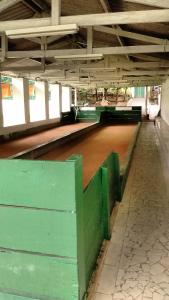 an empty arena with green stalls in a building at Apartamento Hotel Cavalinho Branco in Águas de Lindoia