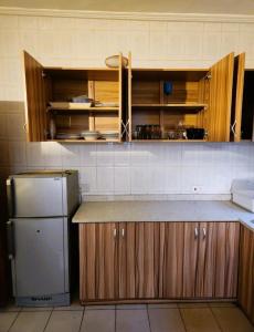 a kitchen with a counter and a refrigerator at Vesper Apt-Osu in Christiansborg