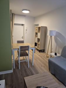 a living room with a table and a bed at Appartement cocooning Sierck-les-Bains in Sierck-les-Bains