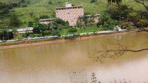 a large building next to a body of water at Apartamento Hotel Cavalinho Branco in Águas de Lindóia