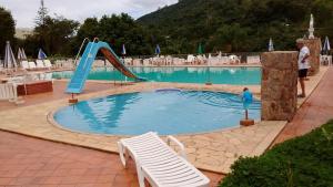 a swimming pool with a slide in the middle of it at Apartamento Hotel Cavalinho Branco in Águas de Lindoia