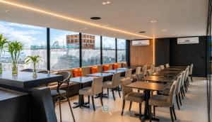 a restaurant with tables and chairs and a large window at Emunah by 123Quarto in Camalaú