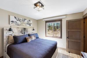 a bedroom with a blue bed and a window at Rost Place Round-Up in Sturgis