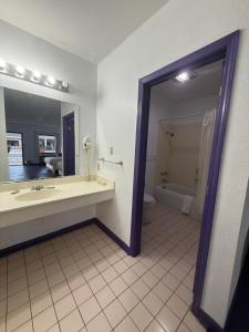a bathroom with a tub and a sink and a mirror at Motel Masquerade in Marksville