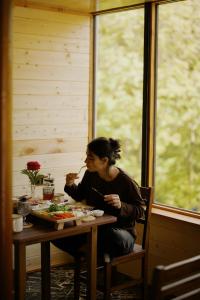 a woman sitting at a table eating food at Debed Glamping in Debed